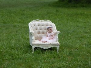 大きい白い椅子の座った赤ちゃん